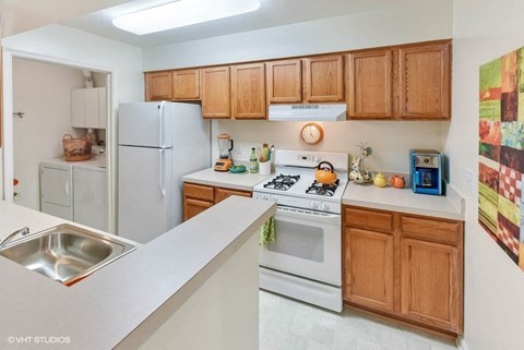 a kitchen with white appliances and wooden cabinets