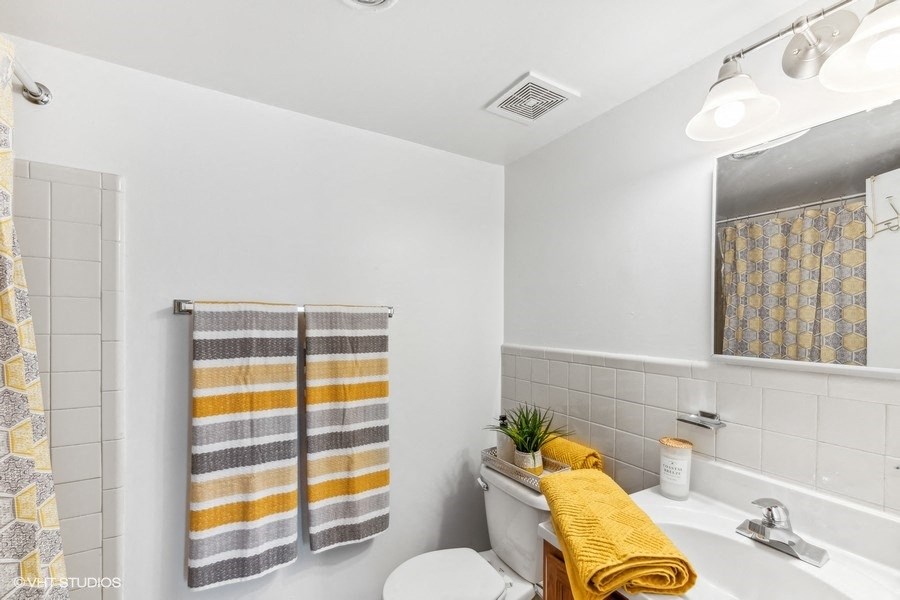 a bathroom with a toilet and a sink and a mirror
