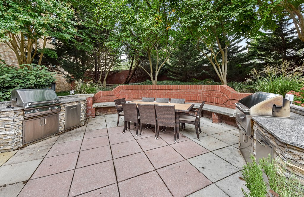 A patio with a table and chairs surrounded by trees.