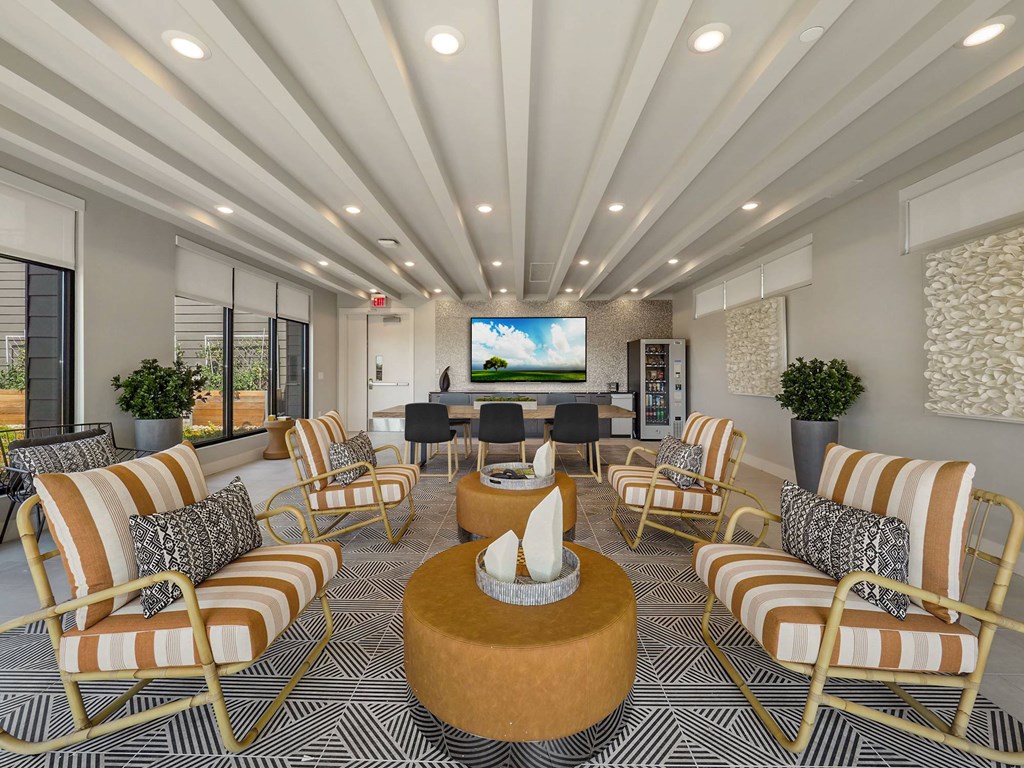 A living room with a large screen TV and striped chairs.