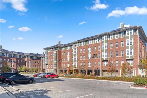 a large brick building with cars parked in a parking lot