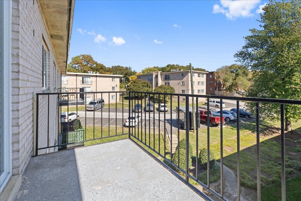 a balcony with a view of a parking lot and buildings