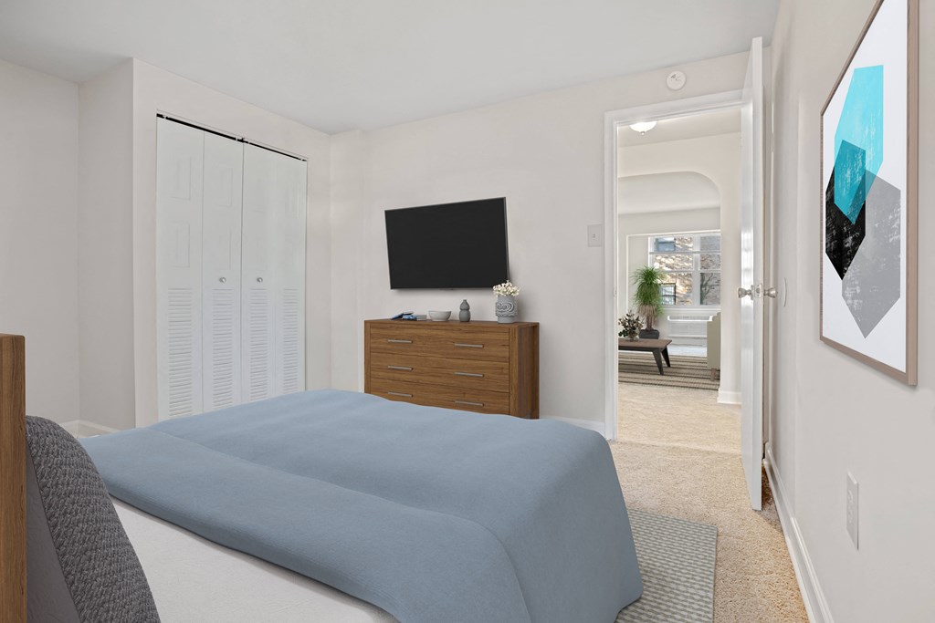 a bedroom with a bed and a tv on the wall