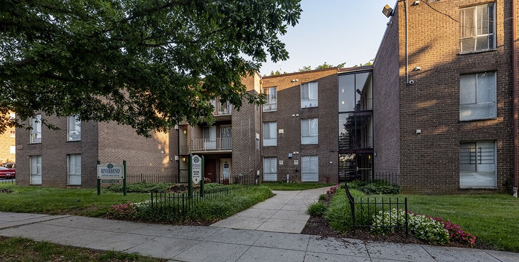 a brick apartment building with a sidewalk in front of it