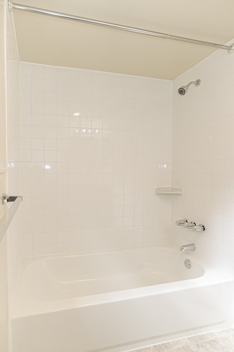 a white bathroom with a tub and a shower