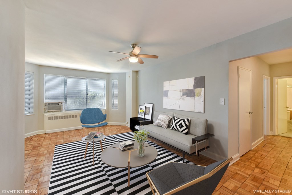 a living room with a couch and a table and a ceiling fan at The Chesapeake, DC