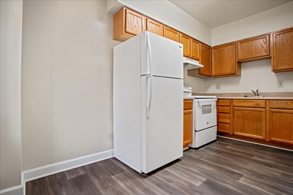 a white refrigerator in a kitchen with wooden cabinets