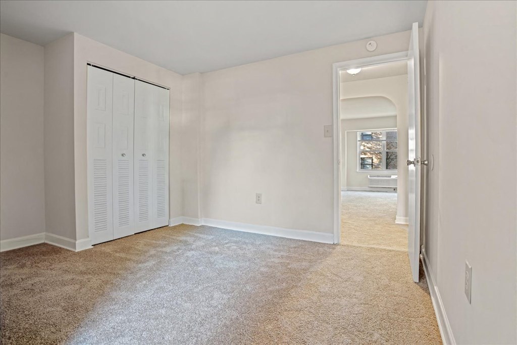 a bedroom with a closet and a door to a hallway