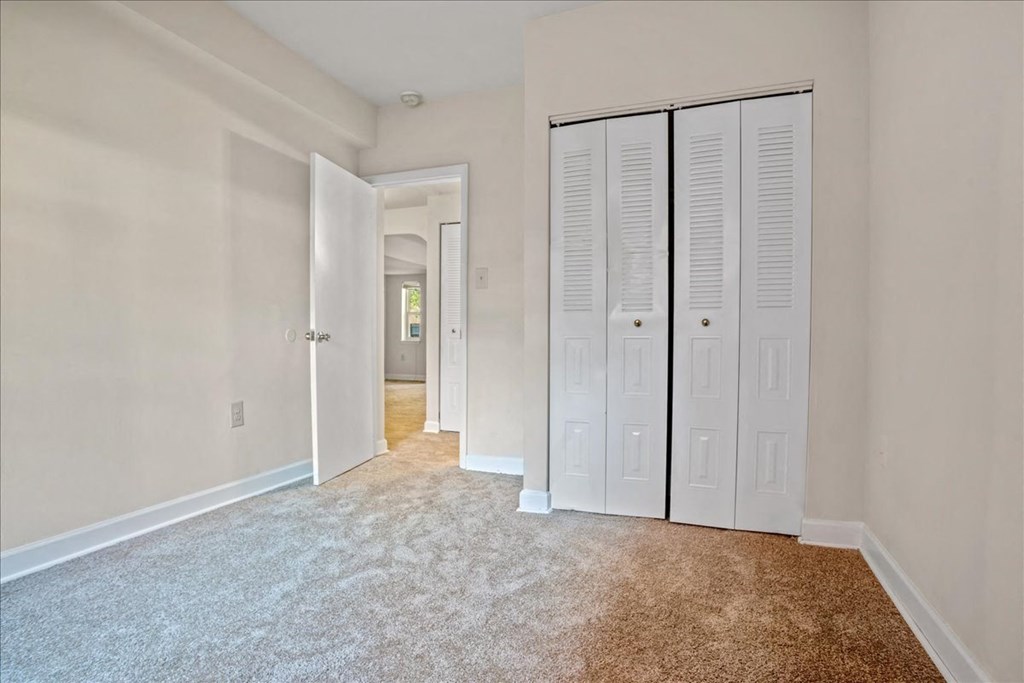 a bedroom with two closets and a hallway with a door