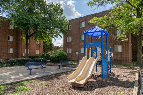 A playground with a blue slide and a blue canopy.