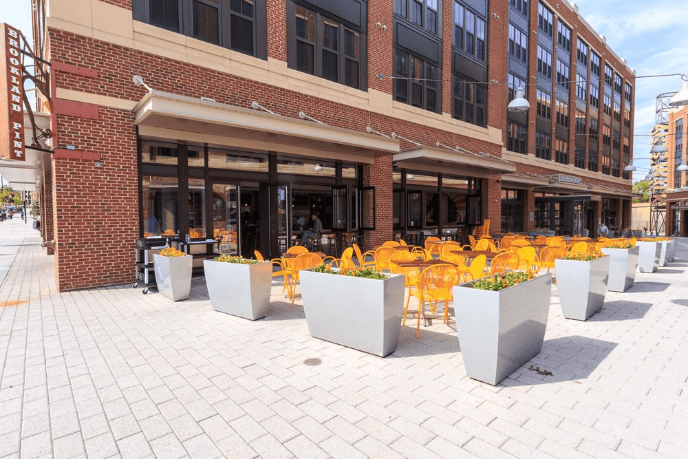 a row of yellow chairs and tables outside of a building