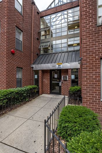the entrance to a brick building with a sidewalk in front of it