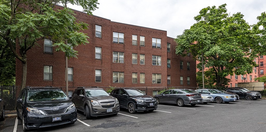 a brick building with a parking lot full of cars
