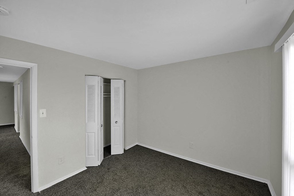 a bedroom with white walls and a closet