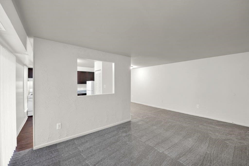 a large empty room with white walls and a tile floor