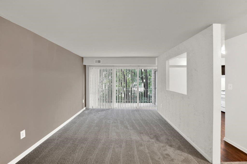 an empty room with a window and a white wall