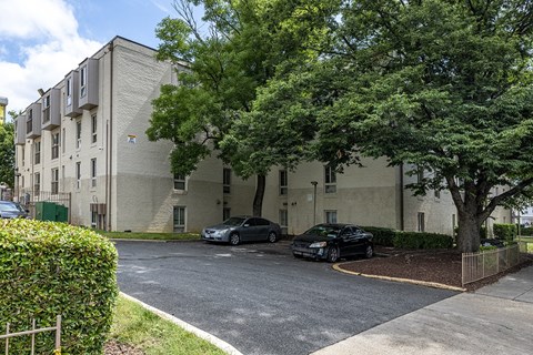a large apartment building with two cars parked in front of it