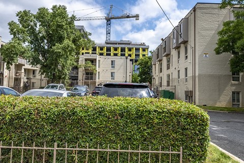a construction site on a city street with cars and a fence