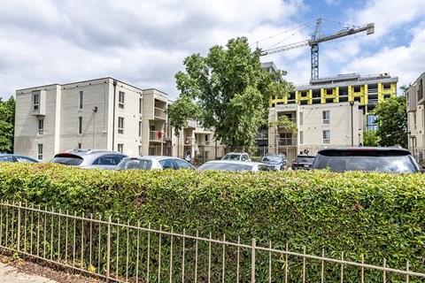a parking lot in front of an apartment building with a crane