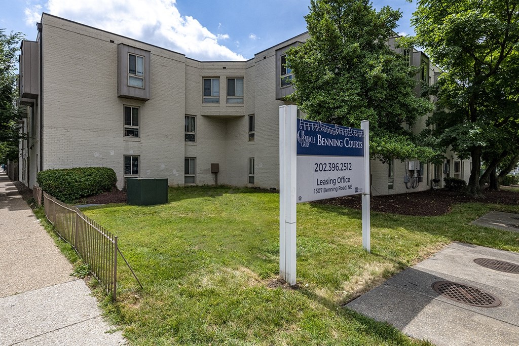 an apartment building with a sign in front of it