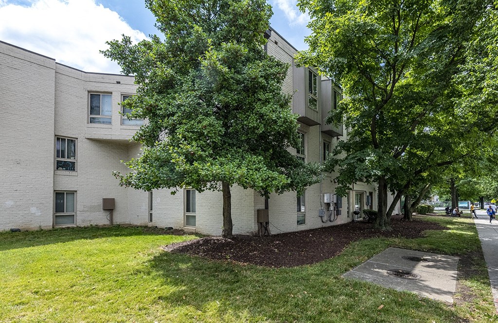 a white apartment building with trees in front of it
