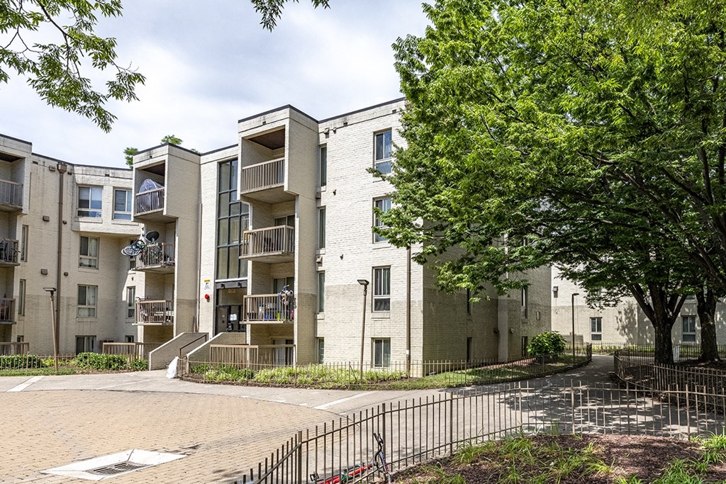 an image of an apartment building with a courtyard and trees