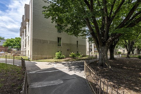 a building with a tree and a sidewalk in front of it