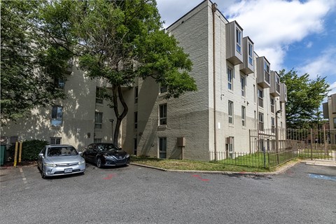 an apartment building with two cars parked in front of it
