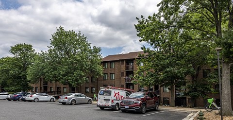 a large brick apartment building with cars parked in a parking lot