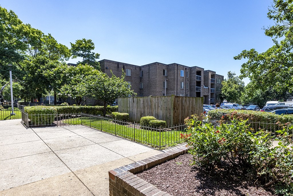 a yard with a fence and a building in the background