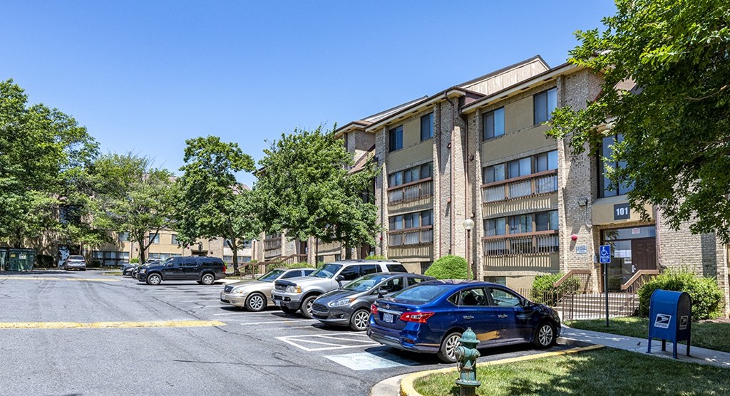 a city street with cars parked in front of an apartment building