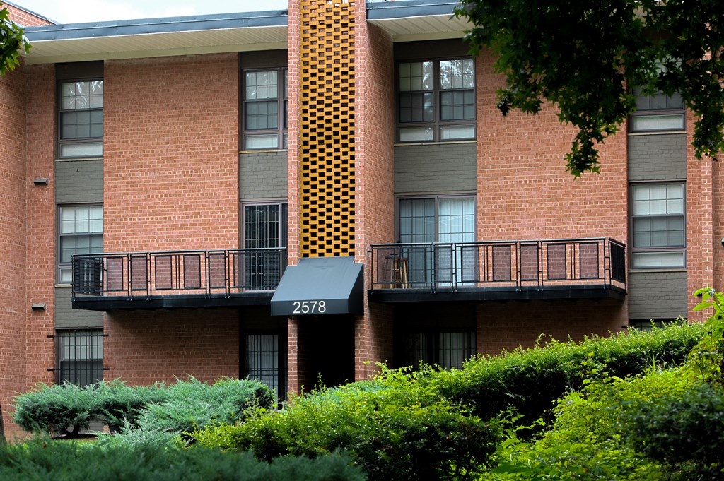 a large brick apartment building with a balcony and a 311 sign