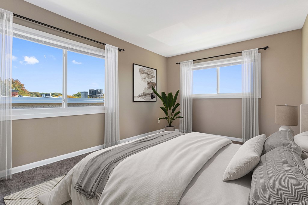 a bedroom with a bed and two windows