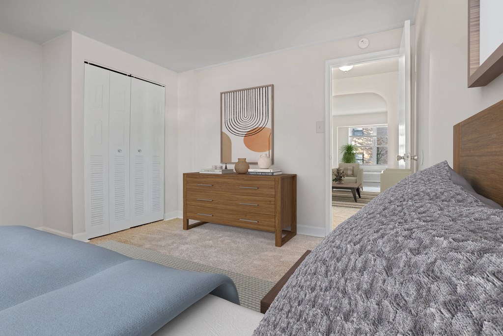 a bedroom with a bed and a dresser with a mirror