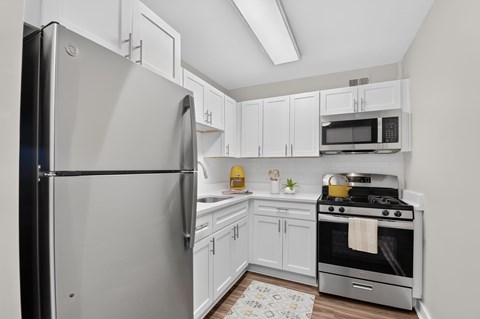 A modern kitchen with a stainless steel refrigerator and oven.
