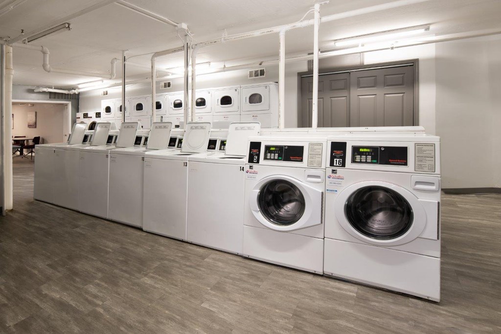 A row of industrial washing machines in a laundry facility.