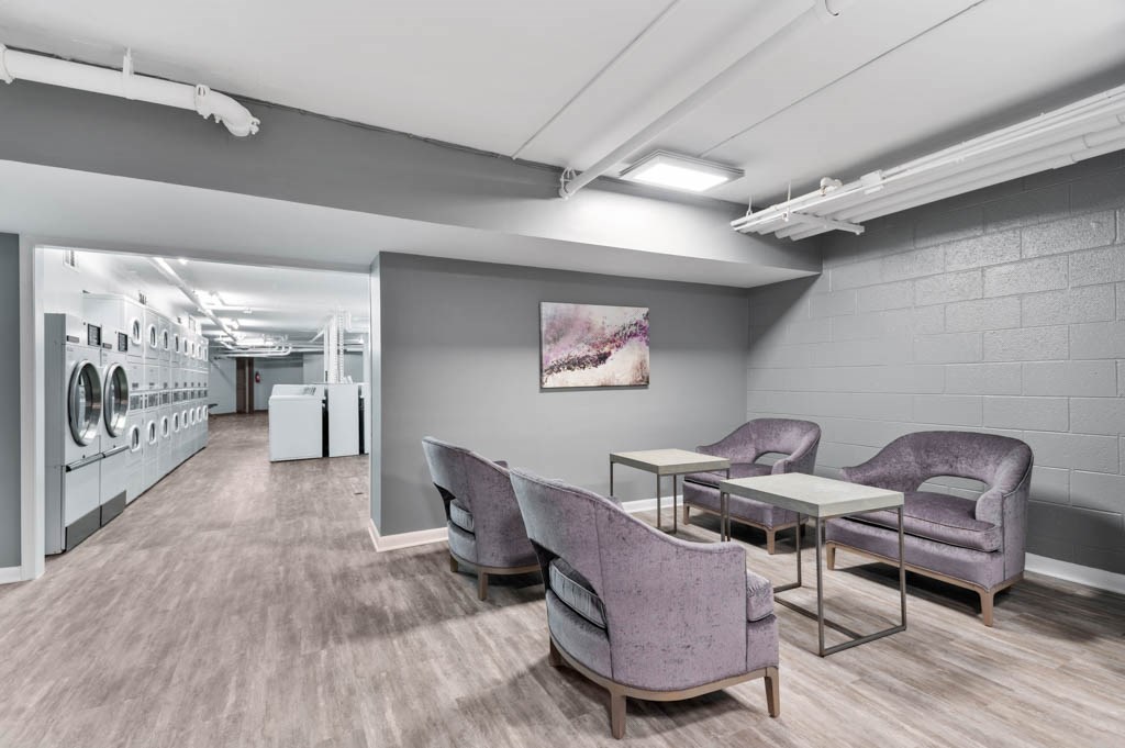 A laundry room with a washer and dryer on the left and a table and chairs on the right.