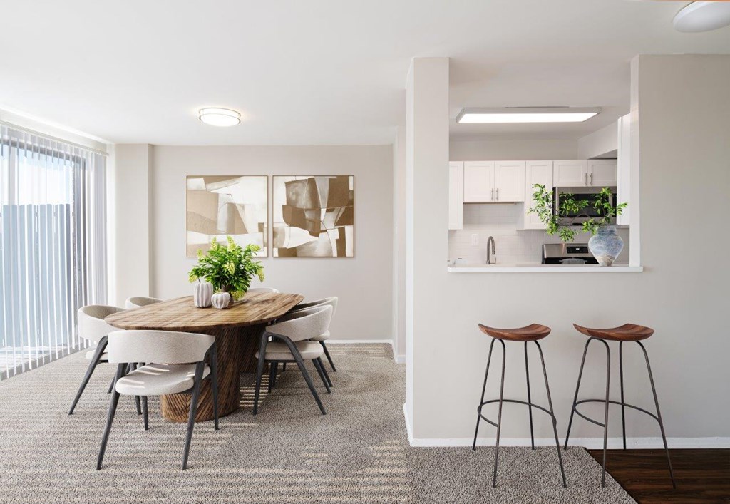 A modern dining room with a round wooden table and white chairs.