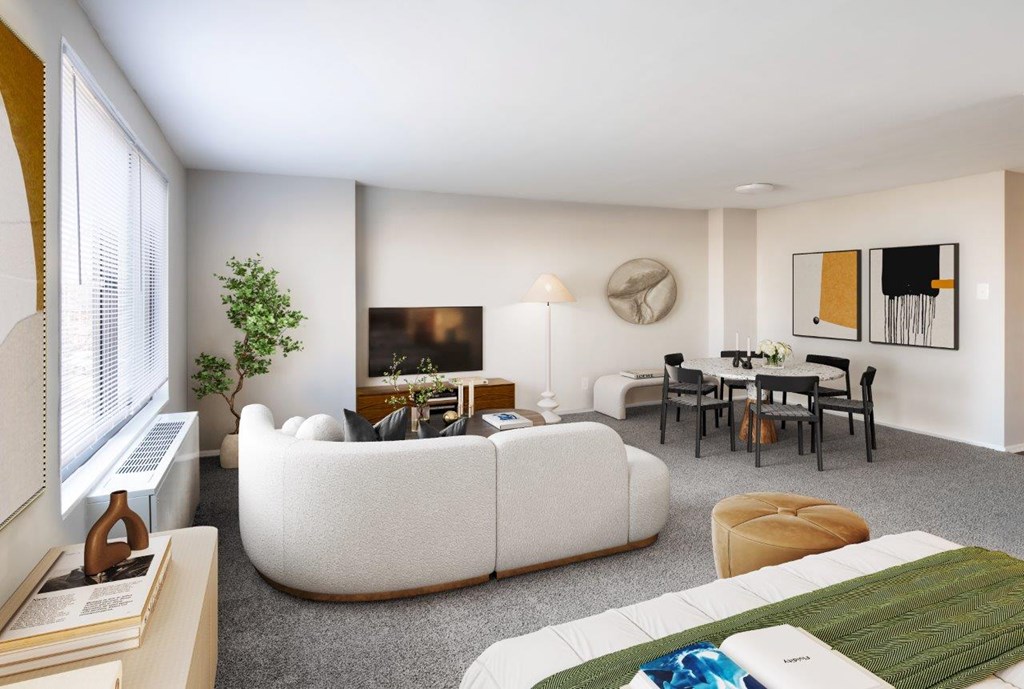 A living room with a white couch, a green rug, and a painting on the wall.