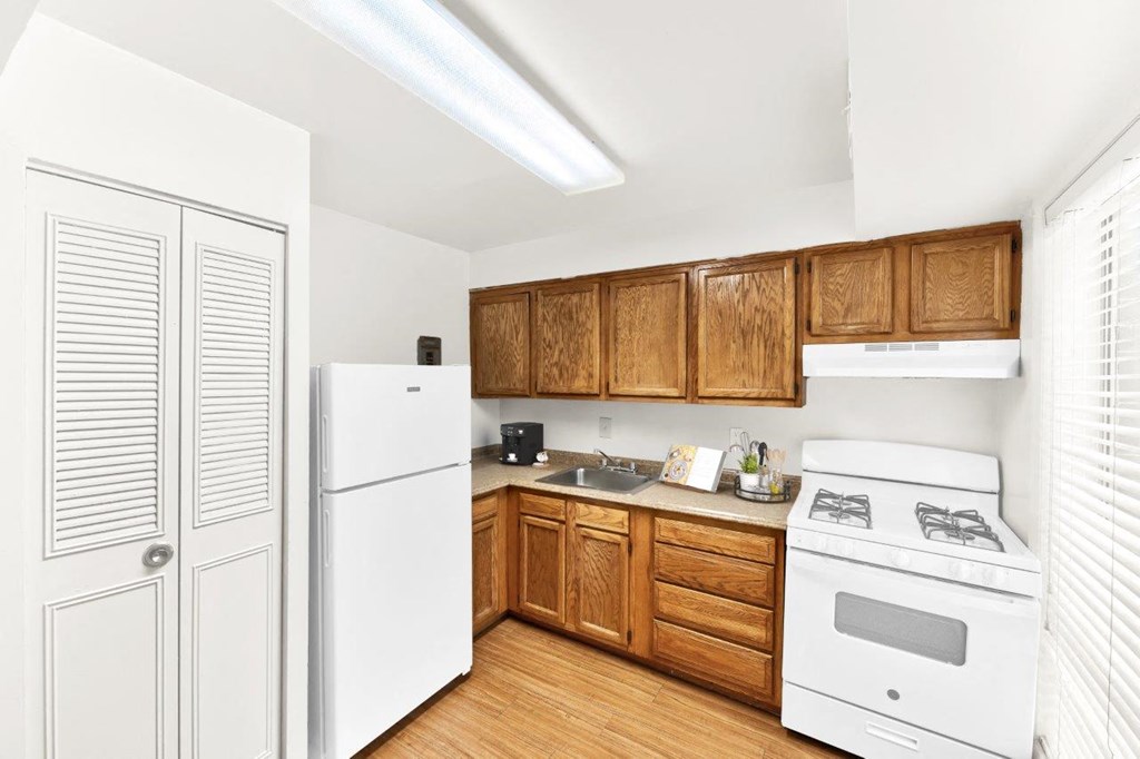 a kitchen with white appliances and wooden cabinets