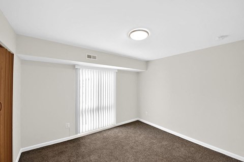 an empty room with white walls and a window