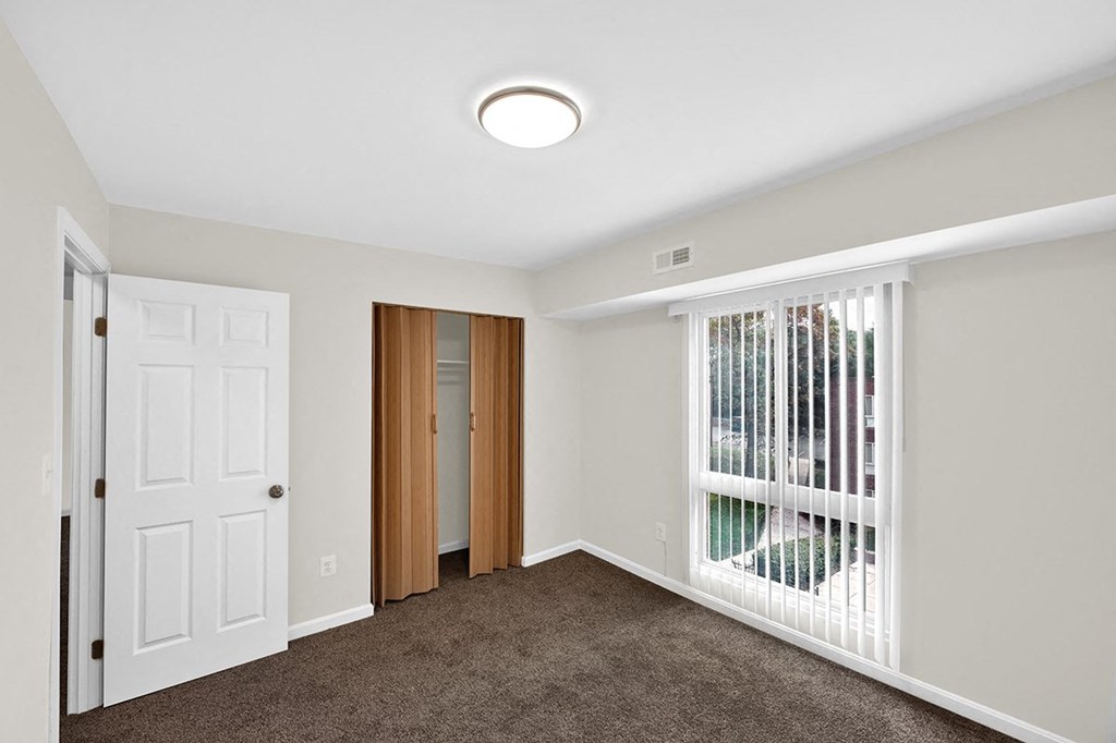 a bedroom with a large window and a white door