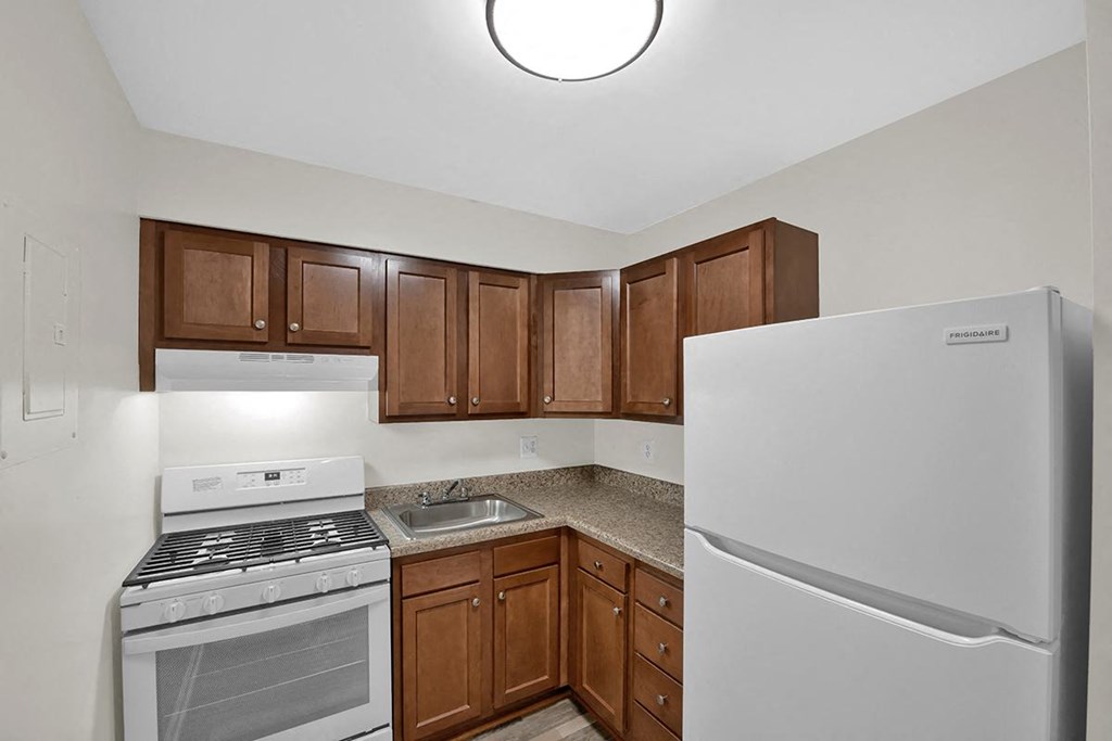 a kitchen with white appliances and brown cabinets