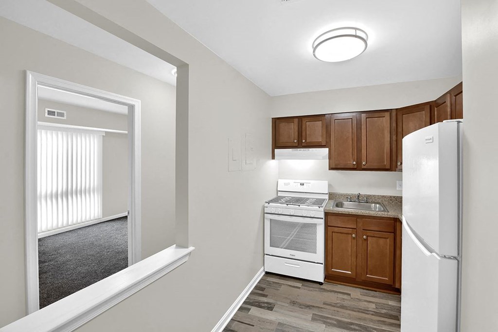 Kitchen with Pass Through Window a kitchen with white appliances and wooden cabinets