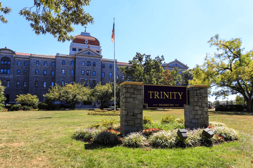 a sign for trinity college in front of a building