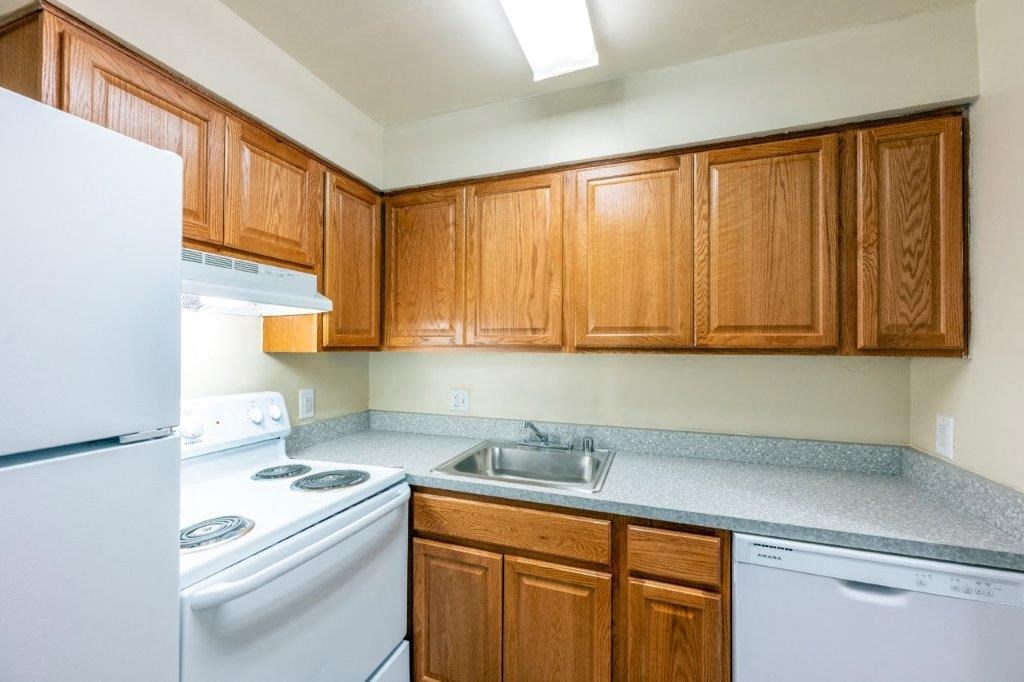 a kitchen with white appliances and wooden cabinets