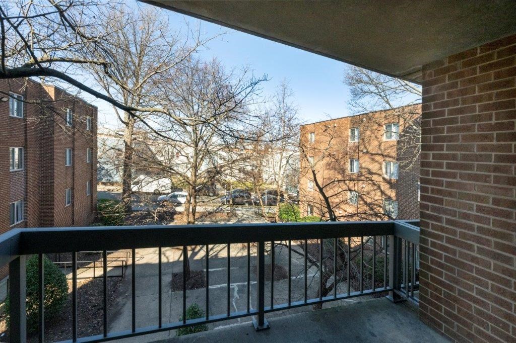 a balcony with a black railing and a brick building