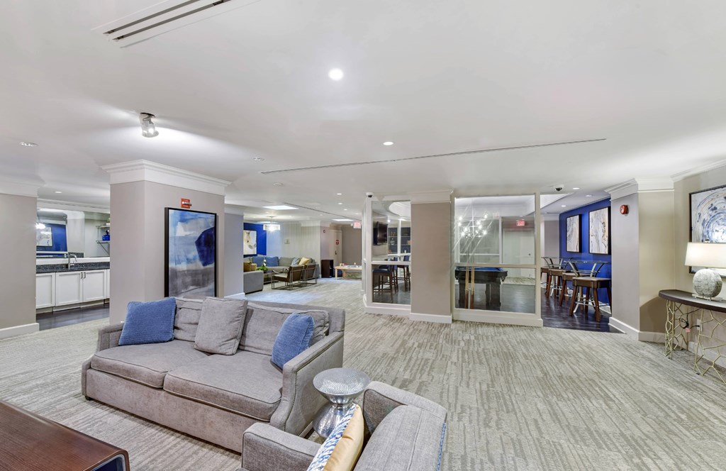 A spacious living room with a grey couch and a television.