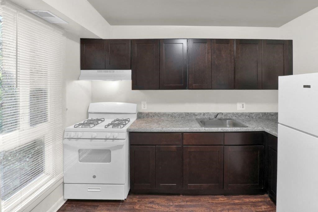 a kitchen with white appliances and dark wood cabinets
