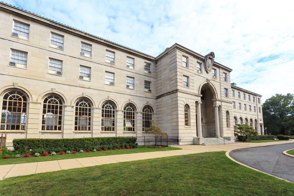 the front of a building with a sidewalk and grass
